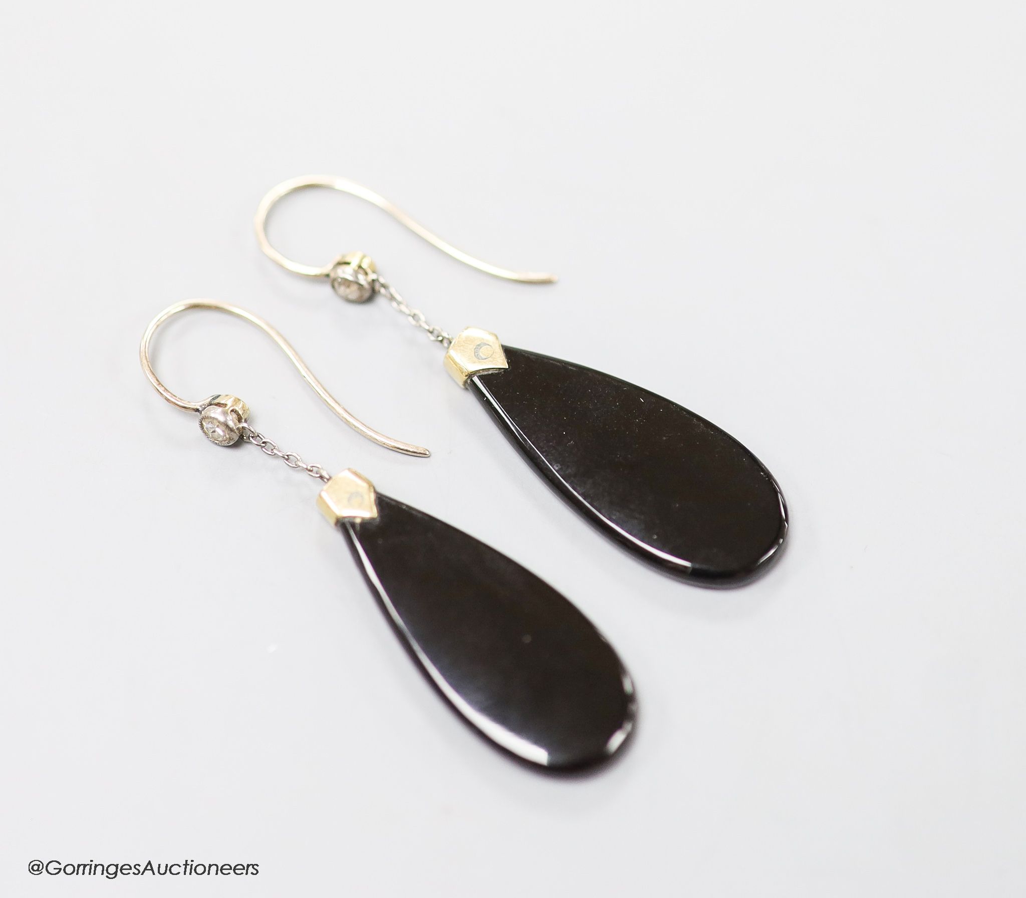 A pair of early 20th century yellow metal mounted black onyx and diamond set pear shaped drop earrings, 40mm, gross 4.6 grams.